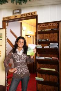 a woman standing in a store holding a book at Pri Ancki B&B Ljubljana suburbs in Medvode