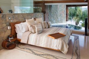 um quarto com uma cama grande e almofadas em El Santuario Resort & Spa em Valle de Bravo