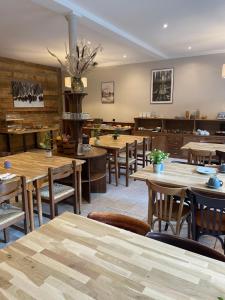 a dining room with wooden tables and chairs at Hôtel du Verdon in Beauvezer