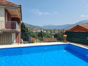 a swimming pool with a view of the mountains at Apartman ZORA s bazenom in Mostar