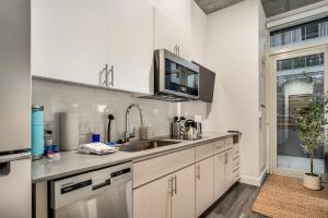 a kitchen with white cabinets and a sink at Boulevard Stays Downtown Highrise STU Sky Pool Parking Gym 01 in Phoenix