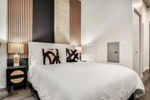 a bedroom with a large white bed with black accents at Boulevard Stays Downtown Highrise STU Sky Pool Parking Gym 01 in Phoenix