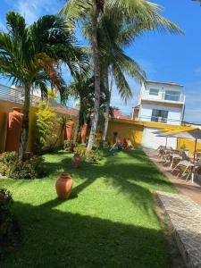 a yard with palm trees and a house at Pousada Gamela do Maragogi in Maragogi
