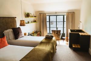 a hotel room with two beds and a couch at Combe Grove Health and Wellness in Bath +30 photos