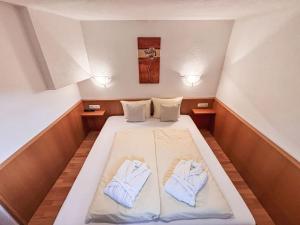 a bed in a small room with two blue slippers at Apartment Apart Edi by Interhome in Kappl