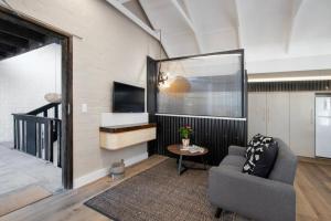 a living room with a couch and a television at Hornbill House Self Catering Accommodation in Hermanus