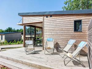 a group of chairs on a deck next to a building at Holiday Home Chalet moderne La Baule-Guérande by Interhome in Guérande