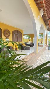 a living room with yellow walls and a wooden floor at Pousada Gamela do Maragogi in Maragogi
