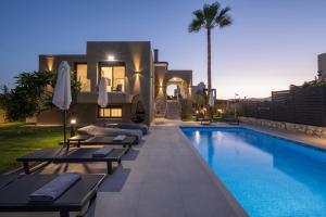 una piscina con tumbonas junto a una casa en Luna Luxury Living, en Tavronitis
