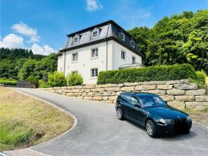 博伦多夫Relax-Bollendorf的一辆蓝色汽车沿着房屋前的路行驶