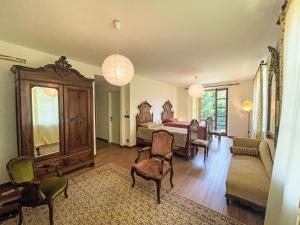 sypialnia z łóżkiem, kanapą i krzesłami w obiekcie Holiday Home Del Respiro by Interhome w mieście Mongardino