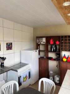 a kitchen with a white refrigerator and a table and chairs at Dunamis in São Gonçalo do Amarante