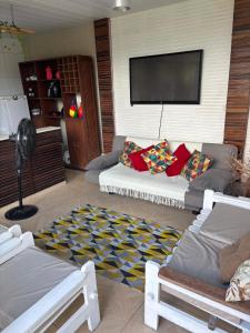 a living room with a couch and a flat screen tv at Dunamis in São Gonçalo do Amarante