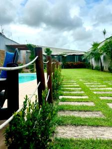 a garden with a fence and a swimming pool at Dunamis in São Gonçalo do Amarante
