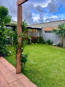 a garden with a wooden pole and a yard at Dunamis in São Gonçalo do Amarante