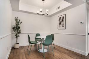 a dining room with a table and green chairs at Boulevard Stays Quiet Modern 2BR Pickleball Pool Parking Gym 05 in Chandler