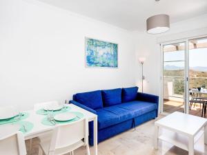 a living room with a blue couch and a table at Apartment Jardines de Manilva I by Interhome in Manilva