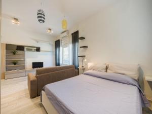 a bedroom with a bed and a couch at Apartment Appartamento Lara by Interhome in Lido di Camaiore