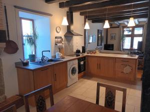 a large kitchen with wooden cabinets and a dishwasher at Gite medieval St Jacques in Parthenay