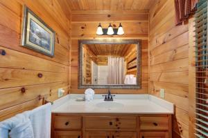a bathroom with a sink and a mirror at Hills Hideaway in Sevierville