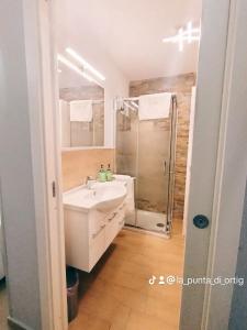 a bathroom with a white sink and a shower at La Punta di Ortigia in Syracuse +9 photos