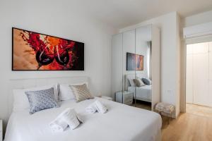 una camera da letto bianca con un letto bianco e un dipinto sul muro di Jappelli Golden House ad Abano Terme Altre 14 foto
