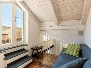 a tiny house with stairs and a blue couch at Holiday Home Entre Collines Et Mar by Interhome in Ventimiglia