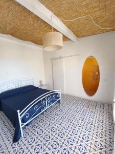 a bedroom with a blue bed and a brown circle on the wall at Circe in Capo Vaticano