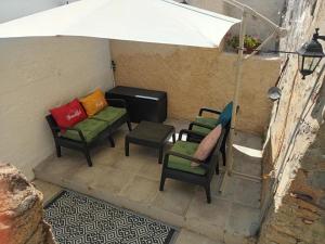 a group of chairs and an umbrella on a patio at Gite medieval St Jacques in Parthenay