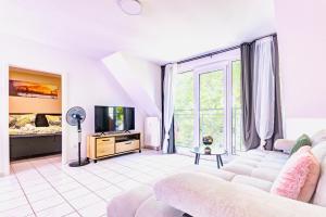 a living room with a couch and a tv at Zentrales City Appartement Worms in Worms