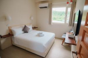 a bedroom with a white bed and a window at 綠島 棲間民宿 Green Island Roost B&B in Green Island