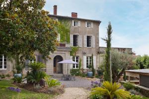 a large house with a garden in front of it at Villa Po'Strophe - Bâtiment classé avec piscine in Clisson
