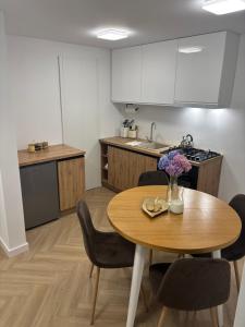 a kitchen with a wooden table and a table and chairs at Apartament u Dyncyka in Krajno Pierwsze