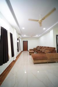 a living room with couches and paintings on the wall at Happy stays in Vijayawāda