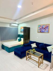 a living room with a blue couch and a bed at Balcony Open Plan Studio Units -Lekki 1, WI-FI, one with balcony, the other without in Lagos
