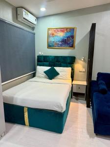 a bedroom with a bed and a blue couch at Balcony Open Plan Studio Units -Lekki 1, WI-FI, one with balcony, the other without in Lagos