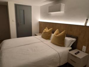 ein Schlafzimmer mit einem großen weißen Bett und gelben Kissen in der Unterkunft Oberbaar 7 in Baar + 3 Fotos