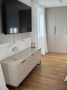 Eine Küche mit weißen Schränken und einem Fernseher an der Wand. in der Unterkunft Oberbaar 7 in Baar