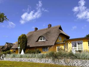 a yellow house with a gray roof at Ferienhaus Brise - Kapitänskajüte in Wieck