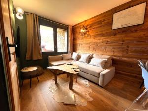 un soggiorno con un divano e un tavolo di Chalet Détente a La Plagne Tarentaise