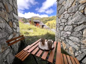 un tavolo da picnic in legno con due tazze sopra di Chalet Détente a La Plagne Tarentaise