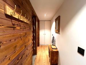 un corridoio con una parete di legno e un tavolo di legno di Chalet Détente a La Plagne Tarentaise Altre 20 foto