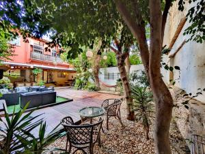 a patio with chairs and a table under a tree at Portrait Boutique Guesthouse in Valencia