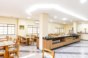 a restaurant with tables and chairs and a buffet at Itapetinga Hotel in Atibaia
