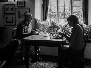 a man and woman sitting at a table with a dog at Lifton Hall in Lifton