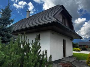 a small white house with a roof at dovolenkový dom TATRAVILL in Stará Lesná