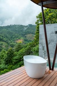 Una bañera situada en una terraza de madera con vistas. en Vianna Villas Chiangmai, en Mae Rim