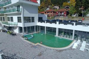 a swimming pool in front of a building at Hotel Bela Jela in Lukovo