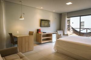 une chambre avec un lit, un bureau et une table dans l'établissement Apto 110 Taiti Villas BobZ, à Barrinha