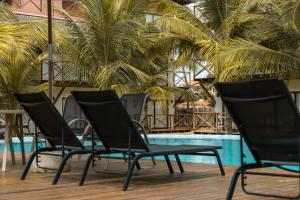 une rangée de chaises noires à côté d'une piscine dans l'établissement Apto 110 Taiti Villas BobZ, à Barrinha 4 autres photos